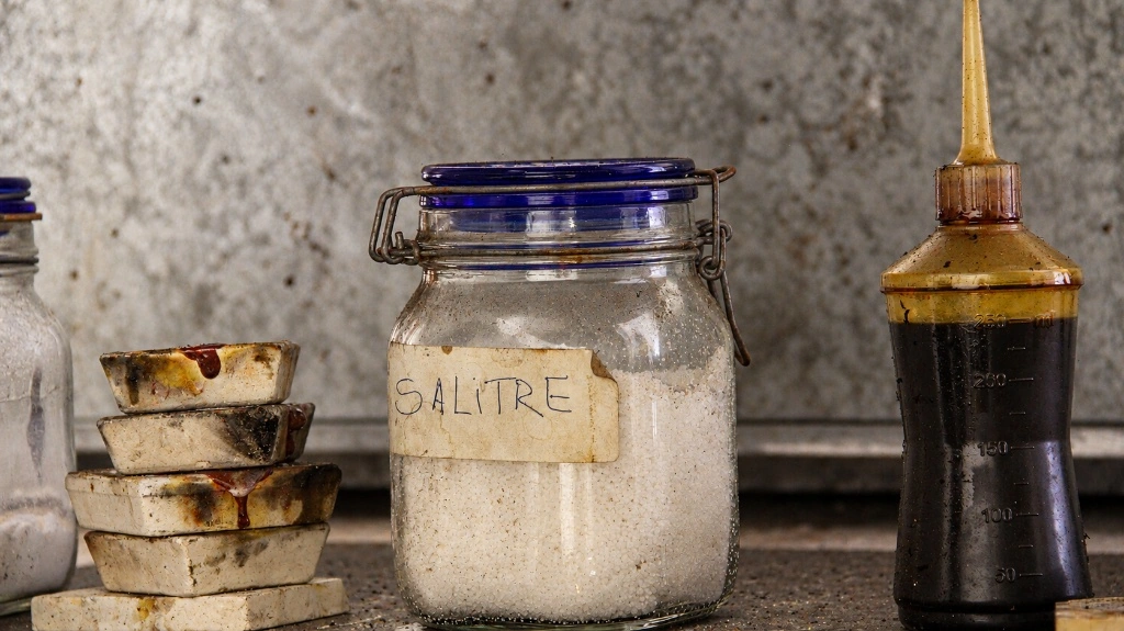 bancada do ateliê: recipiente de vidro com salitre, placas de teste e frasco de óleo